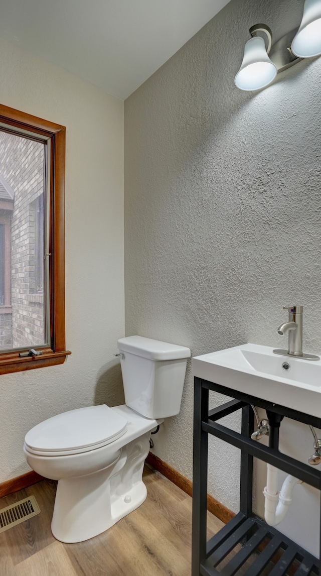 bathroom with toilet and hardwood / wood-style flooring