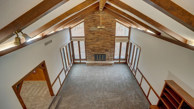 unfurnished living room featuring beam ceiling, high vaulted ceiling, and carpet