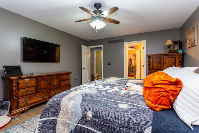 bedroom featuring ceiling fan, light hardwood / wood-style floors, and connected bathroom