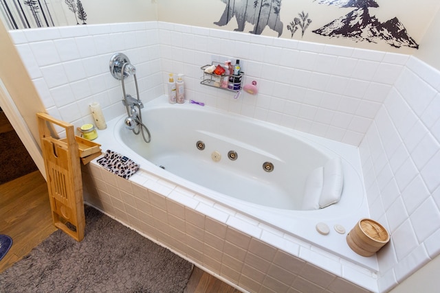 bathroom featuring hardwood / wood-style floors and tiled tub