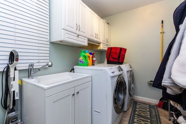 laundry area with cabinets, light tile patterned floors, washer and dryer, and sink