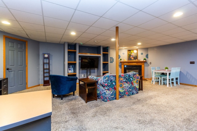 carpeted living room with a paneled ceiling