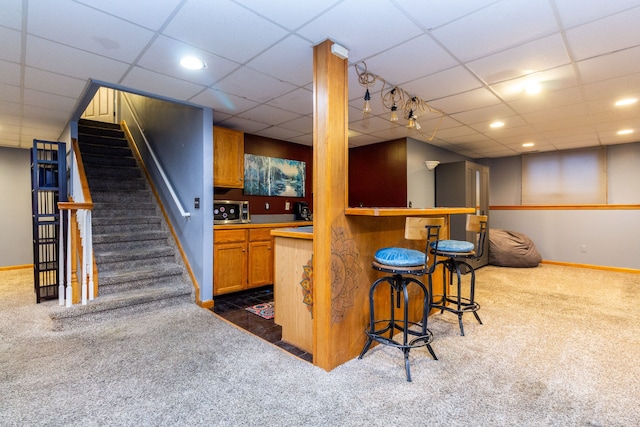 bar with a drop ceiling and dark carpet