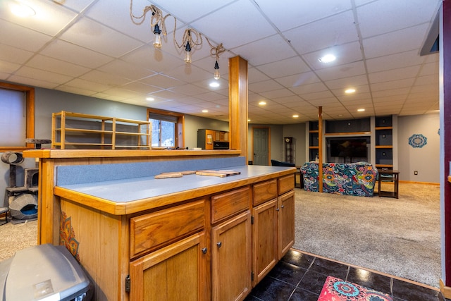 kitchen featuring a drop ceiling and dark colored carpet