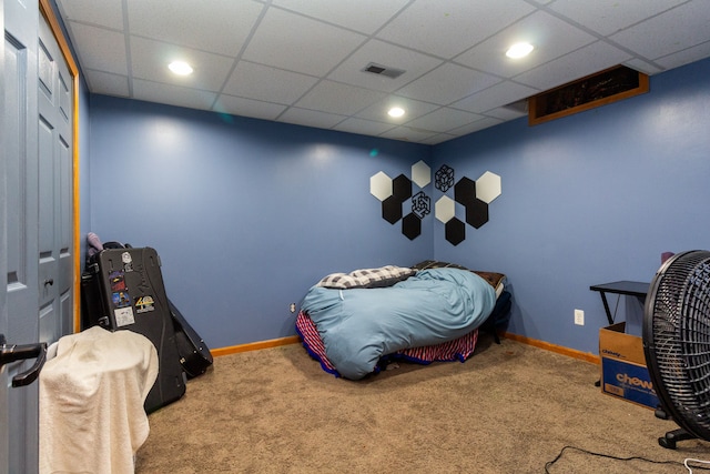 bedroom featuring carpet and a drop ceiling