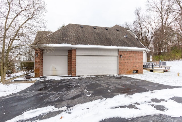 view of snow covered exterior with a deck and a garage