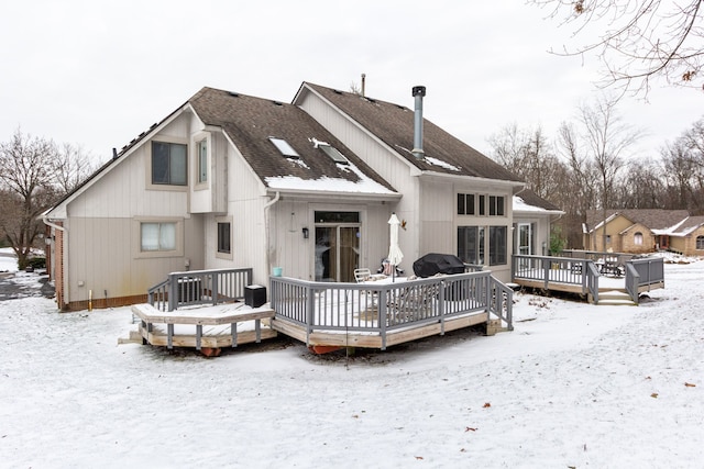 snow covered property with a wooden deck