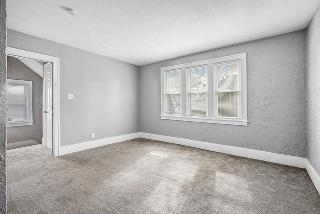 unfurnished room featuring carpet flooring, a textured ceiling, and lofted ceiling