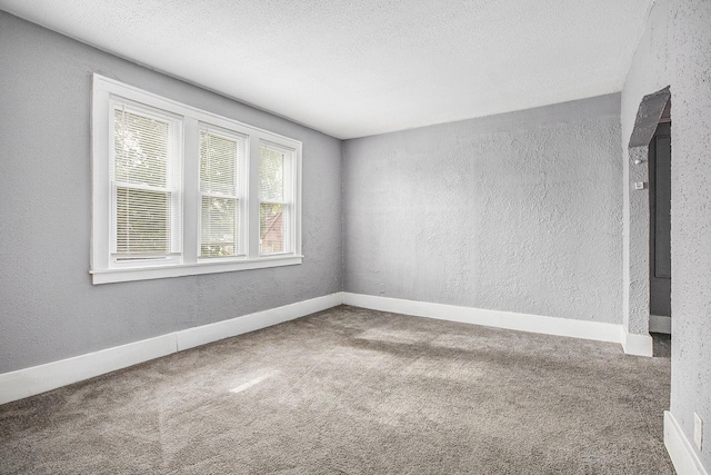 carpeted spare room with a textured ceiling