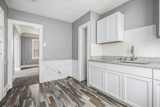 kitchen featuring decorative backsplash, sink, white cabinets, and dark hardwood / wood-style floors