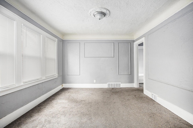 carpeted spare room with a textured ceiling