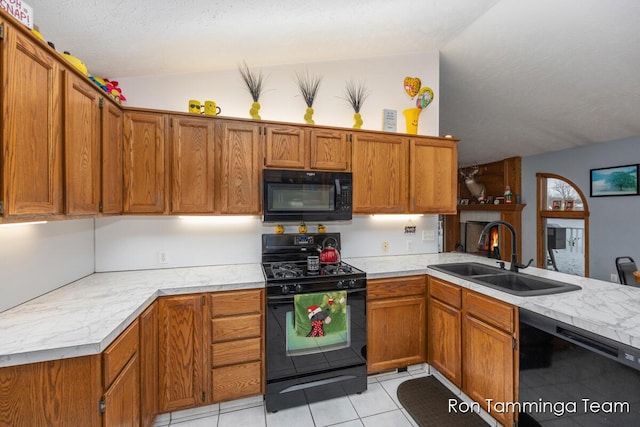 2187 Riley St, Hudsonville, MI 49426 - kitchen featuring black appliances, vaulted ceiling, a sink, light countertops, and brown cabinetry