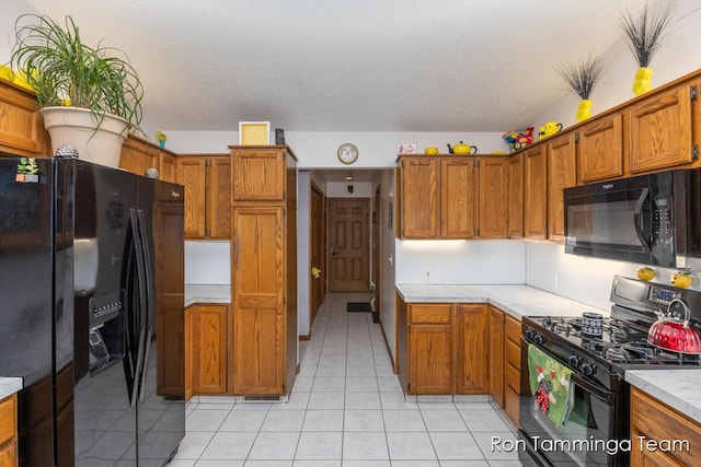 2187 Riley St, Hudsonville, MI 49426 - kitchen featuring black appliances, light tile patterned flooring, brown cabinets, and light countertops