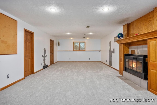 2187 Riley St, Hudsonville, MI 49426 - unfurnished living room featuring light carpet, a tile fireplace, a textured ceiling, baseboards, and recessed lighting