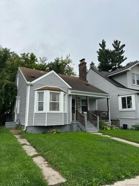 bungalow featuring a porch and a front lawn