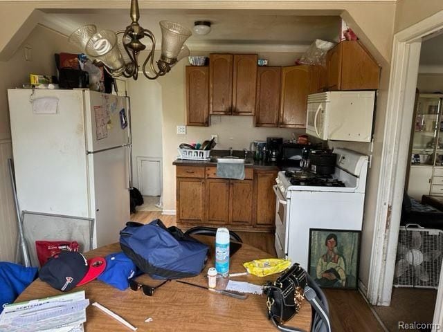 kitchen featuring a notable chandelier and white appliances