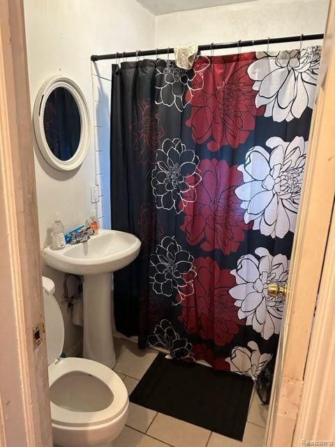 bathroom with tile patterned flooring, sink, a shower with shower curtain, and toilet