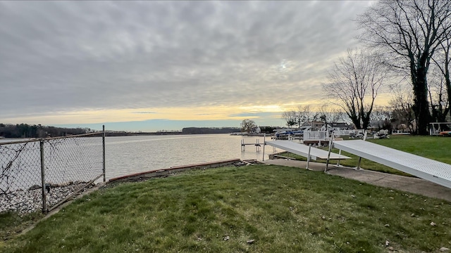 exterior space featuring a lawn and a water view