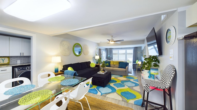 living room with wood-type flooring, washer / clothes dryer, and ceiling fan