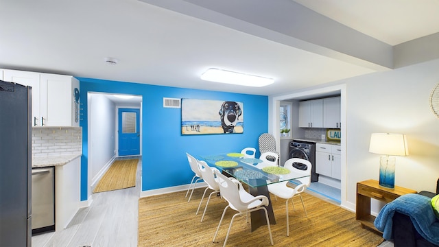 dining area featuring washer / clothes dryer and light hardwood / wood-style floors