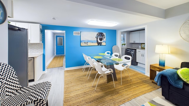 dining area featuring light hardwood / wood-style floors and washer / dryer