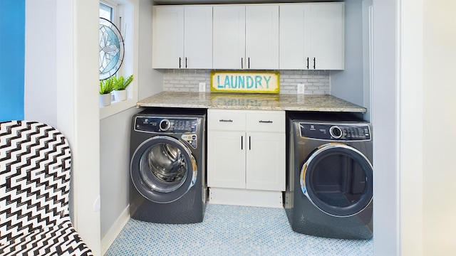 laundry room with washer and dryer and cabinets