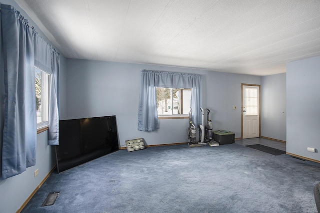 empty room with carpet floors and a textured ceiling