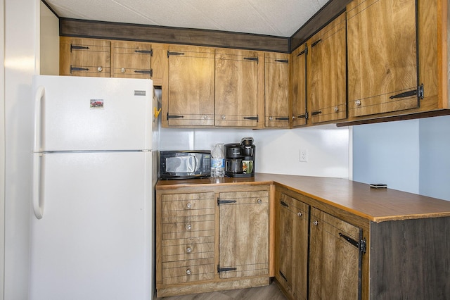 kitchen with hardwood / wood-style floors, white fridge, and kitchen peninsula