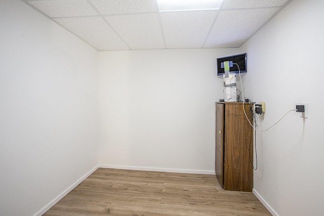 empty room featuring a paneled ceiling and light hardwood / wood-style flooring