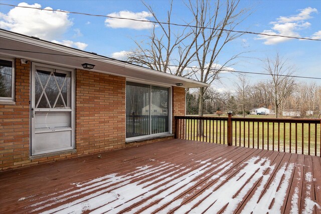 snow covered deck featuring a lawn