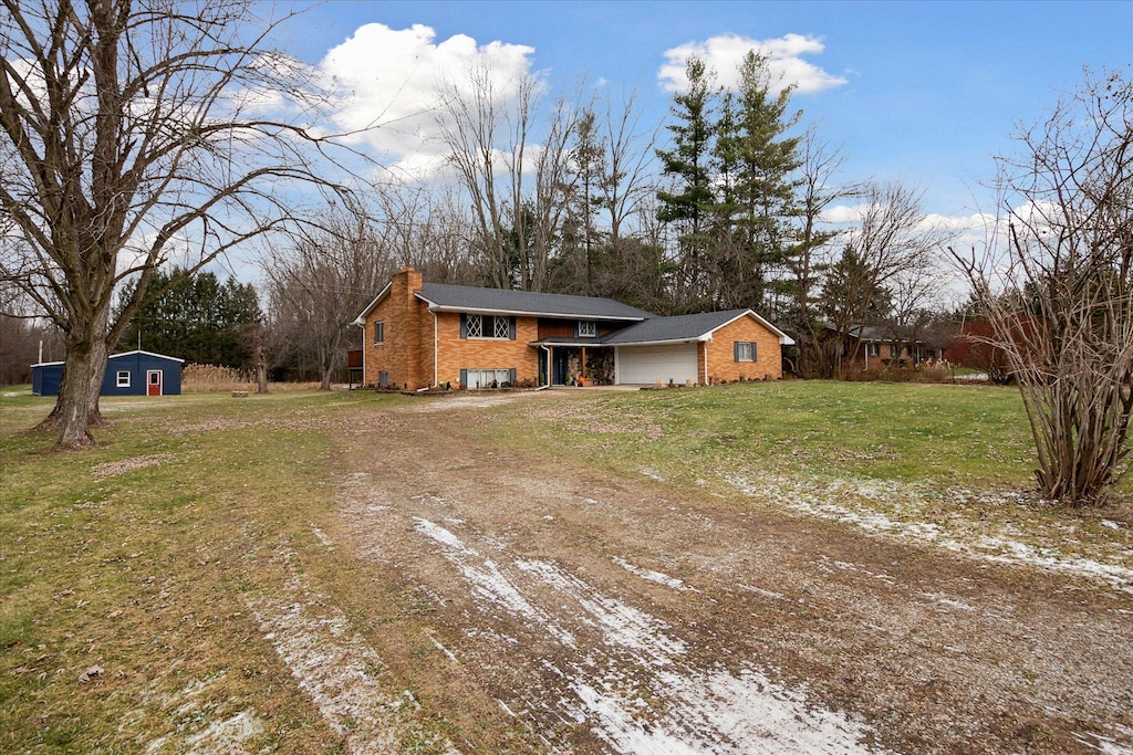 view of front of home with a storage unit and a front lawn