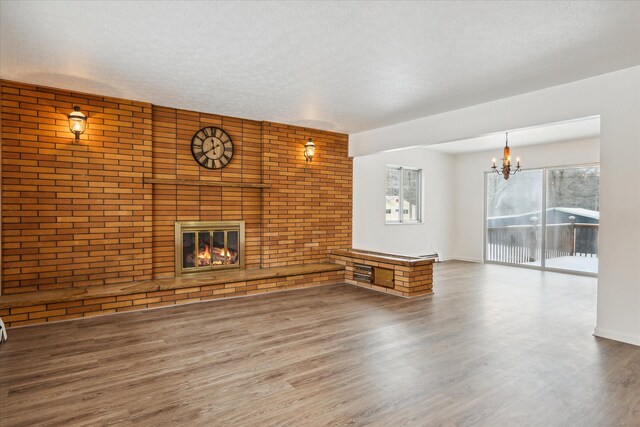 unfurnished living room featuring hardwood / wood-style floors, a fireplace, and a textured ceiling