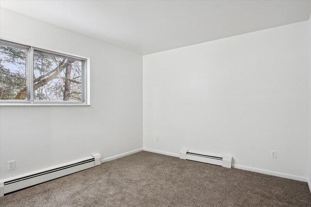 spare room featuring baseboard heating and carpet