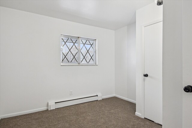 carpeted spare room featuring a baseboard radiator