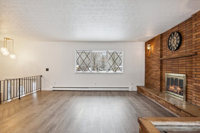 unfurnished living room featuring a brick fireplace, hardwood / wood-style flooring, a textured ceiling, and a baseboard heating unit