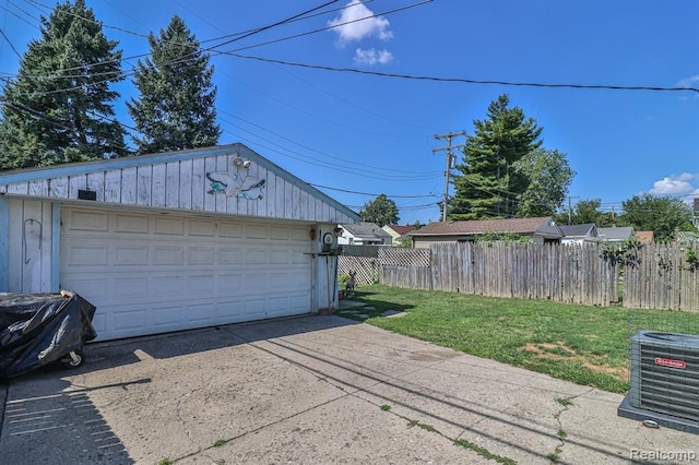 garage featuring central AC unit and a yard