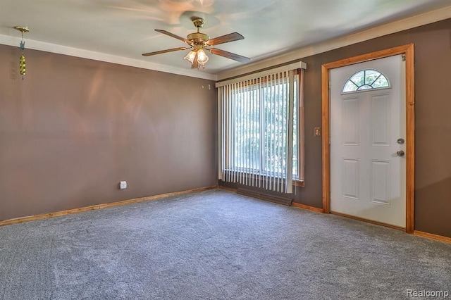 foyer entrance with carpet, ceiling fan, and ornamental molding