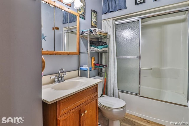 full bathroom featuring vanity, toilet, combined bath / shower with glass door, and wood-type flooring