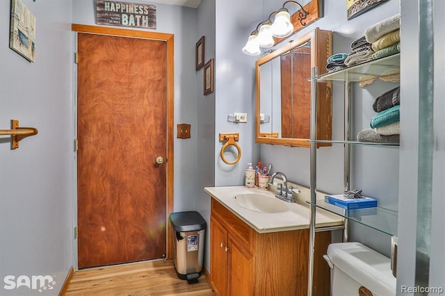 bathroom with vanity, wood-type flooring, and toilet