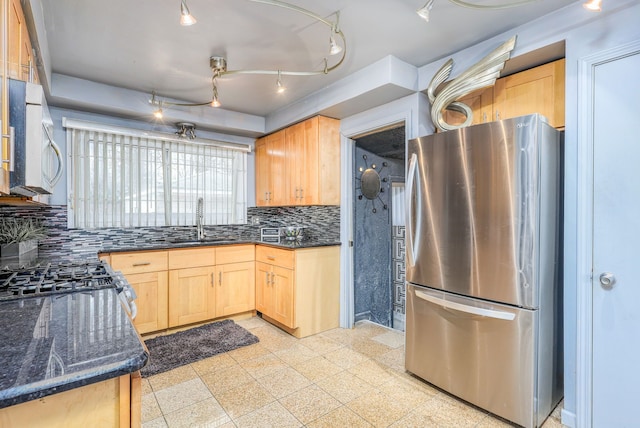 kitchen with tasteful backsplash, stainless steel fridge, light brown cabinets, and sink