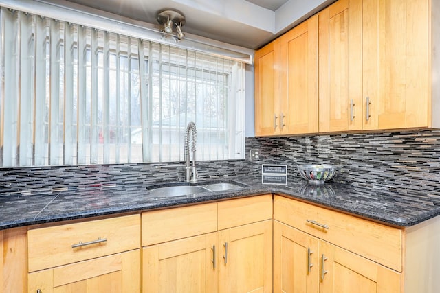 kitchen featuring decorative backsplash, sink, light brown cabinetry, and dark stone counters