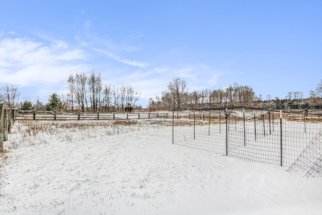 snowy yard with a rural view
