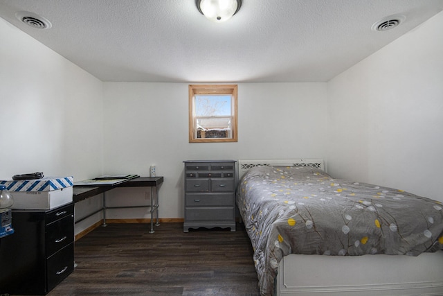 bedroom with dark wood-type flooring and a textured ceiling