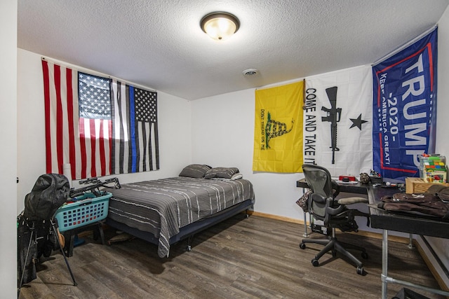 bedroom with hardwood / wood-style floors and a textured ceiling
