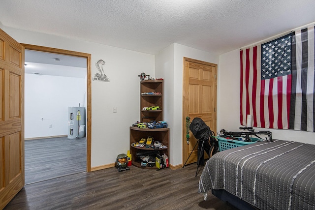 bedroom featuring electric water heater, dark hardwood / wood-style flooring, and a textured ceiling