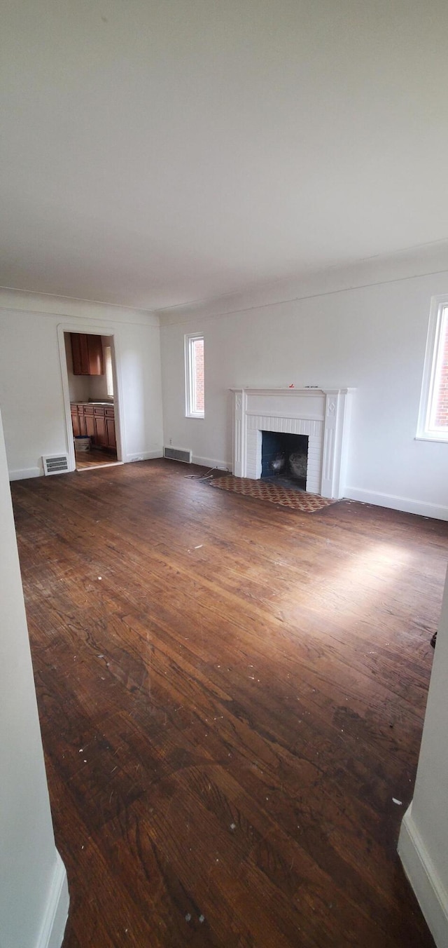 11828 College St, Detroit, MI 48205 - unfurnished living room featuring ornamental molding, dark wood-type flooring, and a brick fireplace