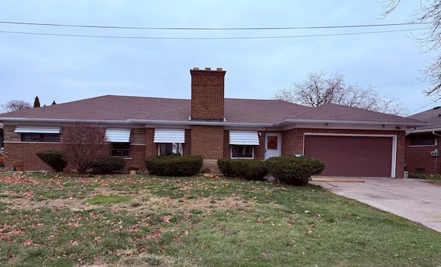 view of front of house featuring an attached garage, a front yard, a chimney, and brick siding