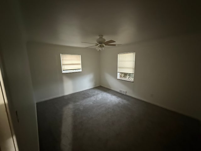 carpeted spare room with ceiling fan