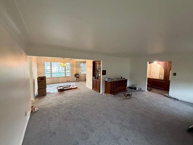 unfurnished living room with light carpet and an inviting chandelier