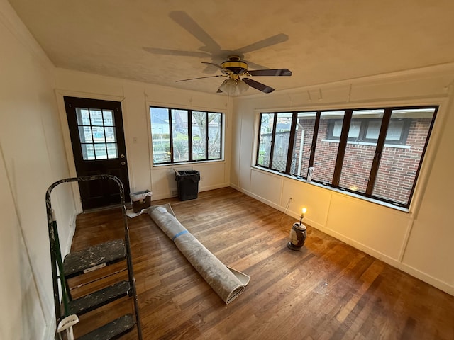 exercise room with ceiling fan and wood-type flooring